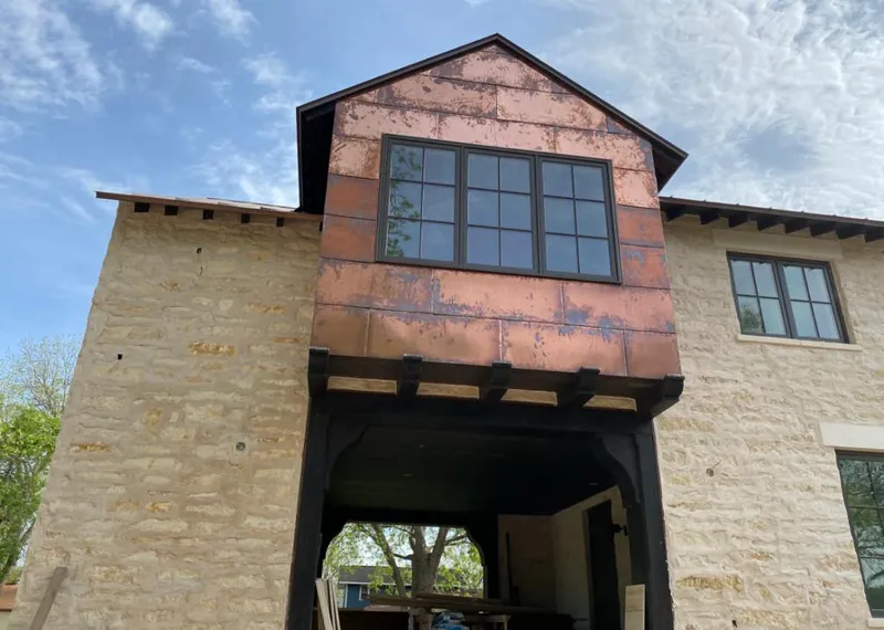 Copper metal panel facade on a stone building for Roof Repair in Farmers Branch